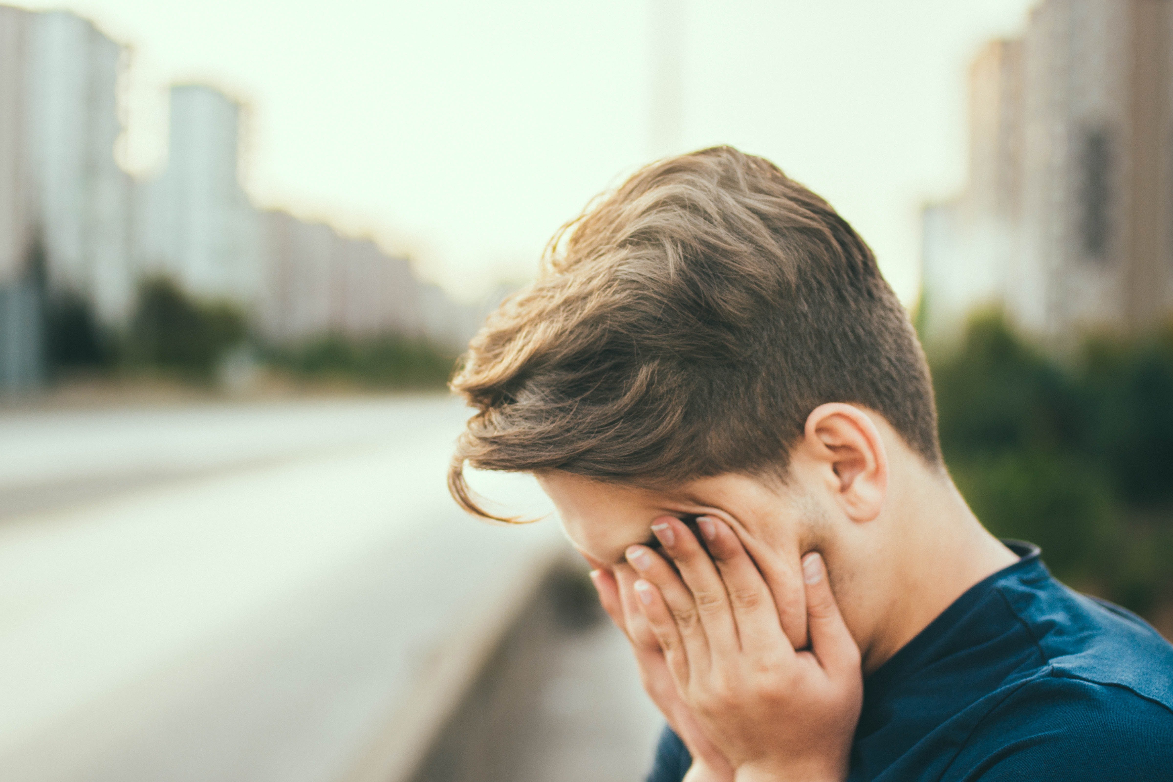 young man covering eyes with headache