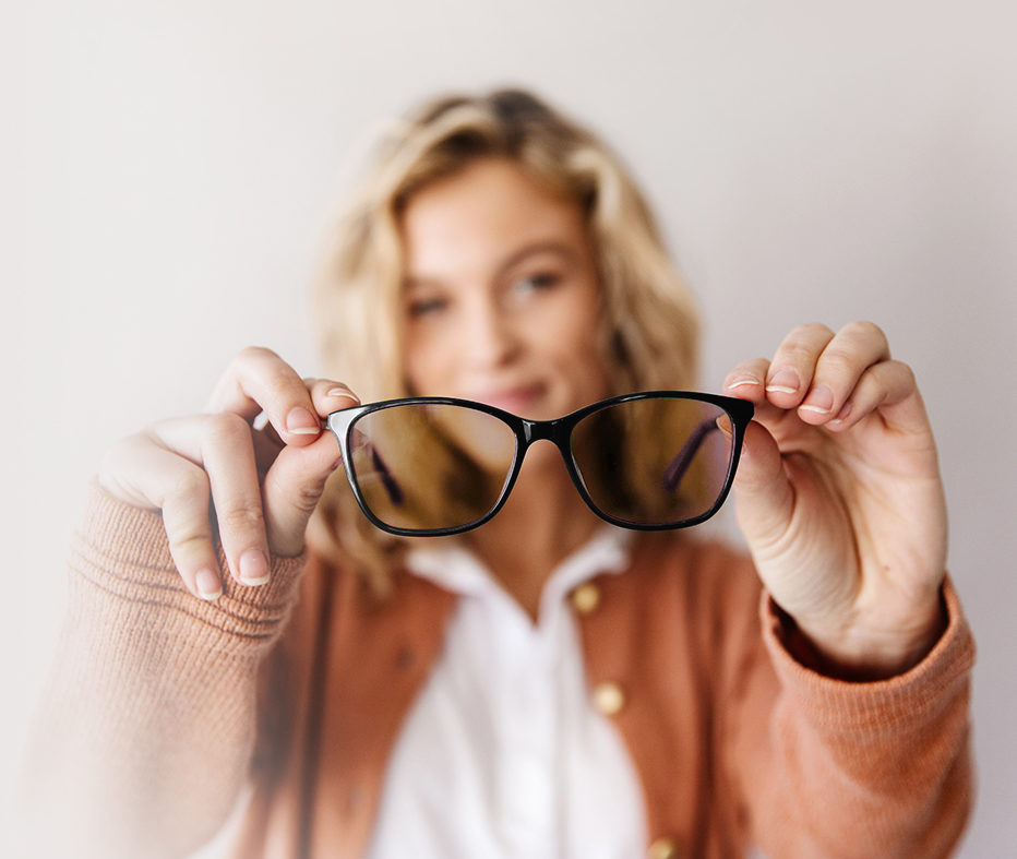 woman holding axon optics migraine glasses powered by avulux lenses